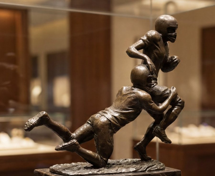 Bronzefigur zweier Footballspieler beim Tackle, ausgestellt in einer Glasvitrine